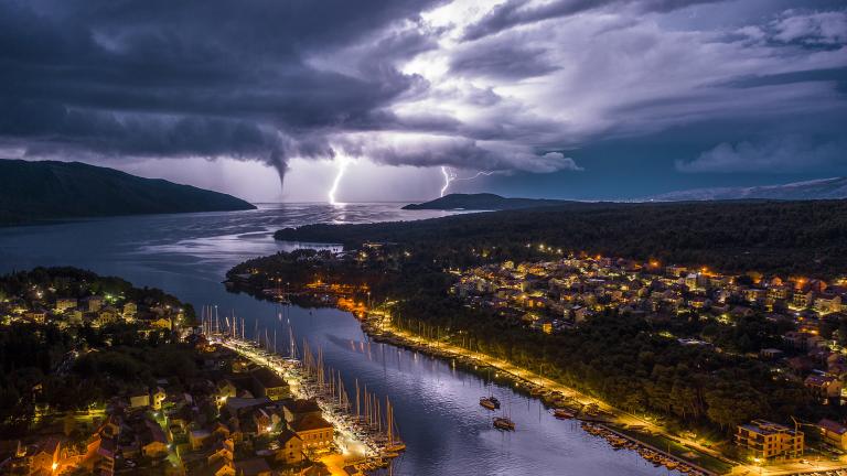 Lightning over a city and lake at night.
