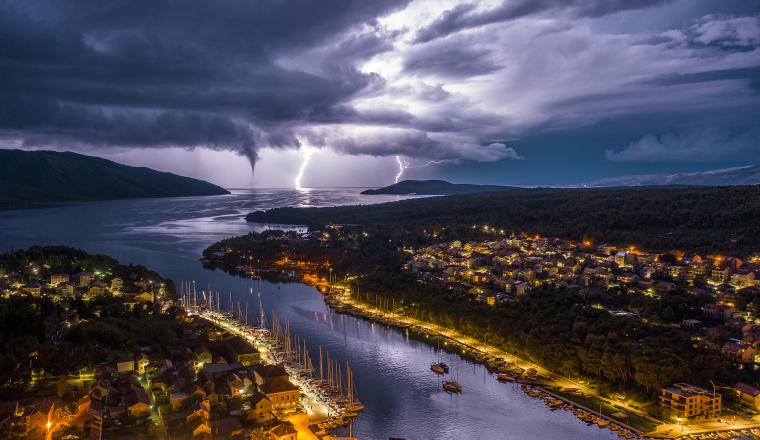 Lightning over a city and lake at night.