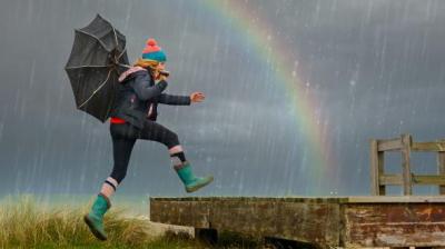 Woman walking in front of a rainbow