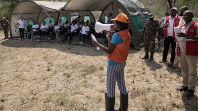 A group of people standing in front of tents.