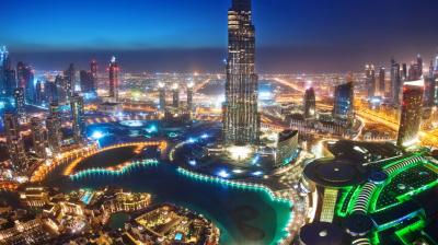 The burj khalifa tower is lit up at night.