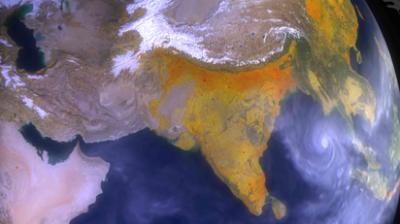 Satellite view showing the Indian subcontinent, parts of the Middle East, and a cyclone spiraling over the Bay of Bengal.