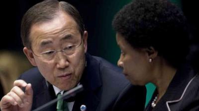 Two people in formal attire are having a serious conversation at what appears to be an official meeting or conference.