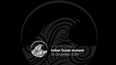 Abstract wave pattern with text: "In remembrance, Indian Ocean tsunami, 26 December 2004" on a black background.
