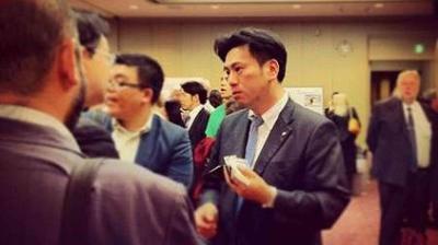 A group of people in business attire conversing at an indoor networking event or conference.