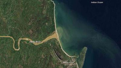 Aerial view showing the Umfolozi River flowing into the Indian Ocean near the town of Mtubatuba, with green land and coastal waters visible.