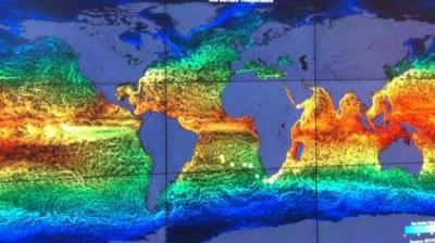 Color-coded world map showing ocean surface temperatures, with warmer areas in red and orange near the equator and cooler areas in green and blue toward the poles.