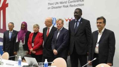 Seven people stand in a row at the Third UN World Conference on Disaster Risk Reduction, with a conference banner visible in the background.