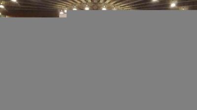 A symmetrical ceiling with a radial wooden beam design and multiple round lights arranged in a circular pattern.