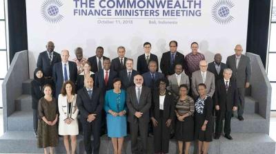 Group photo of attendees at the Commonwealth Finance Ministers Meeting on October 11, 2018, in Bali, Indonesia. A mixed group of men and women are standing on a multi-level platform.