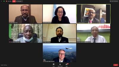 A screenshot of a virtual meeting with seven participants, each visible in their individual video frames against various backgrounds.