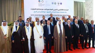 A group of people in formal attire stand together in front of a banner for the Sixth Arab Regional Platform for Disaster Risk Reduction.