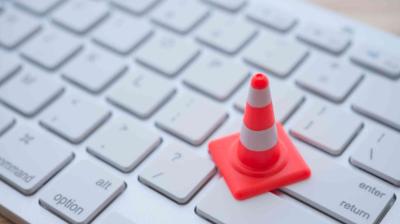 A small traffic cone model placed on a white computer keyboard.